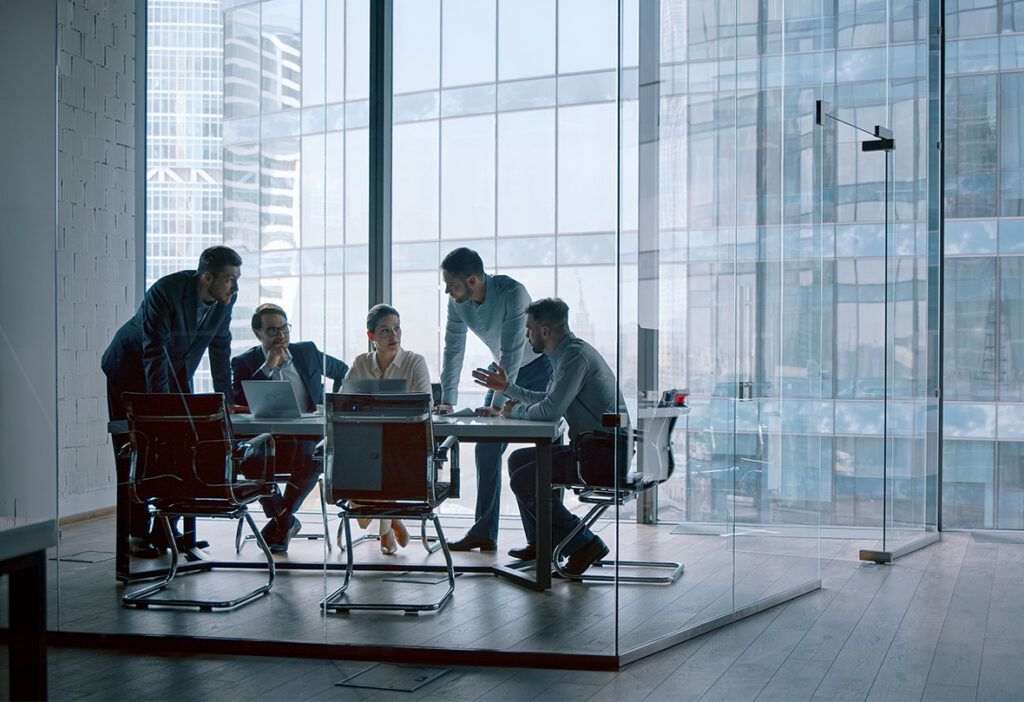 Business team collaborating in a glass conference room.